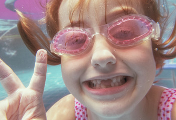 Girl with goggles diving in swimming pool © Rawpixel.com