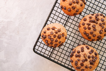 Chocolate chip cookies on a wire rack on white stone background