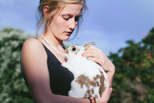 Girl holding a white pet rabbit