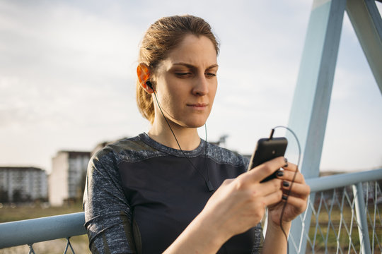 Young female runner looking at the phone