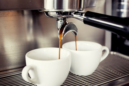 Freshly made quality coffee dripping into two coffee cups