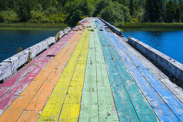 Pride flag painted on bridge over lake