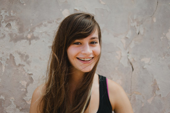 Teenaged Girl Smiling Against Urban Wall