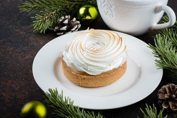 Delicious Christmas Dessert. Lemon tartlet tart with with meringue and cup of hot chocolate with marshmallow on dark stone concrete table background. Christmas Holiday Decoration