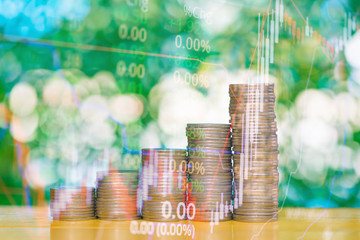 Double exposure of stacks of coins with stock exchange price of stock market chart, business...