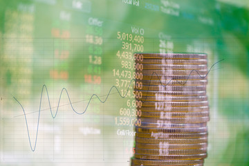 Double exposure of stacks of coins with stock exchange price of stock market board, business...