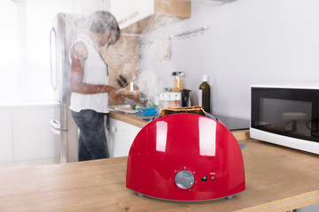 Close-up Of A Red Toaster With Burnt Toast