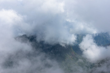Aerial view on mountain peaks through cloud
