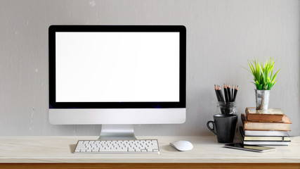 Mockup of Modern desktop computer with empty screen and stationery items on light table in workspace interior.