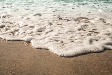 Background soft wave of Sea with foam on sandy beach.