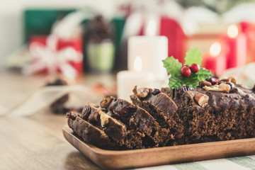 Delicious dried mixed nut Christmas fruit cake on wooden plate