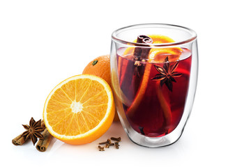 Double wall glass cup with mulled wine, spices, orange, anise and cinnamon sticks isolated on white background.