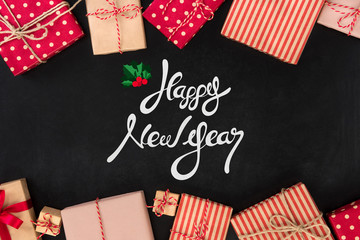 Happy New Year text on blackboard background with gift boxes