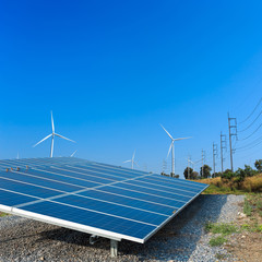 Solar panels and wind turbine against blue sky. Solar cell, solar engergy