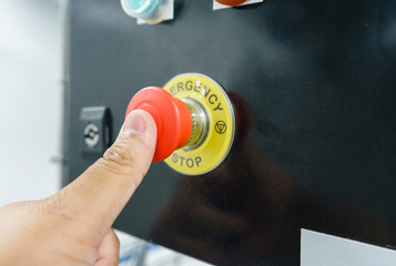 Hand pressing the red emergency button or stop button for industrial machine, Emergency Stop for...