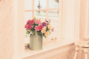 Fototapeta na wymiar Flowers in vase on window