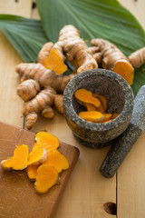 Fresh turmeric and turmeric Sliced on wooden background