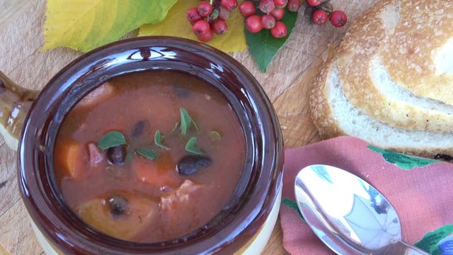 Portuguese Bean Soup. A bowl of hearty bean soup with smoked ham hock, linguica sausages, carots and onions