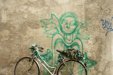 old bicycle against wall with angel graffiti