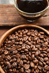cup of coffee and coffee beans in wooden bowl