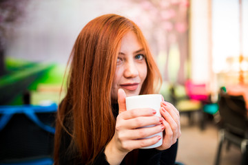 Beautiful girl drinking coffee at the coffee shop