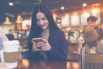 Photo businesswoman wearing suit, touching smartphone screen and smiling.