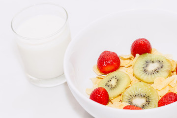 Cornflakes cereal and strawberry and milk on white table