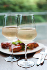 Two glasses of delicious cooled white wine with snack in restaurant..