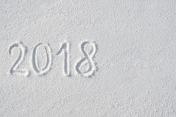 2018 text letters handwritten on flat snow surface. New year holiday seasonal postcard, greeting card.
