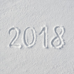 2018 text letters handwritten on flat snow surface. New year holiday seasonal postcard, greeting card.