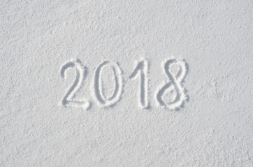2018 text letters handwritten on flat snow surface. New year holiday seasonal postcard, greeting card.