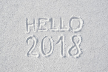Hello 2018 text letters handwritten on flat snow surface. New year holiday seasonal postcard, greeting card.