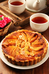 Freshly baked hot apple pie on wooden table          
