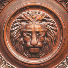 Head of a lion in a circle is a wooden bas-relief, background