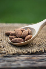 Roasted almonds on wooden spoon for healthy eating, organic food for good living life style 