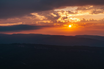 Dramatic sunset summer landscape in mountains with sun at dawn