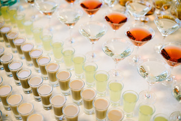 Many glasses of colorful Cocktails on the white table