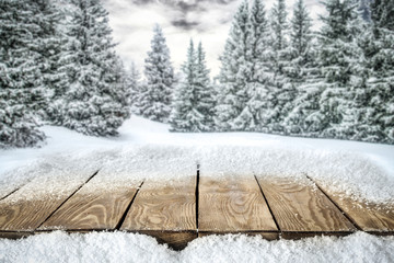 A table full of snowflakes with space for your product advertisement. Winter landscape of trees...