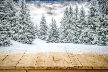 A table full of snowflakes with space for your product advertisement. Winter landscape of trees...