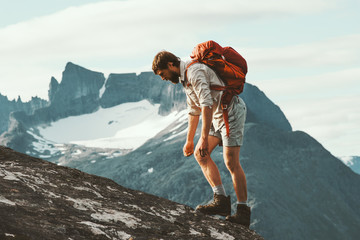 Tired Man in mountains with backpack Norway Travel lifestyle hiking hard trek concept adventure...