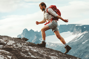 Man adventurer skyrunning in mountains with backpack Norway Travel hiking lifestyle concept active...