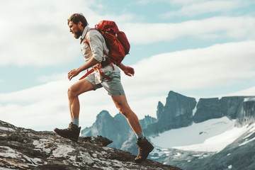 Man trail running in mountains with backpack Norway Travel hiking lifestyle concept active weekend summer vacations wild trek