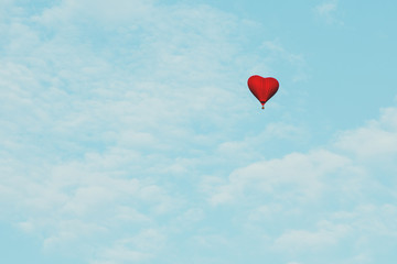 Obraz na płótnie Canvas Heart shape balloon love symbol flying in the blue sky Valentines day gift celebration help and charity concept