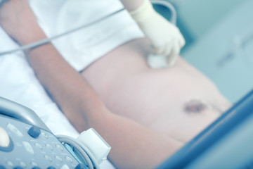Naklejka premium Doctor provides ultrasound scan to the male patient