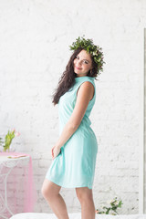 brunette girl in a mint dress and a wreath of flowers