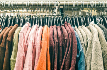 Second hand pullover clothes hanging on shop thrift at flea market store - Hipster wardrobe sale...