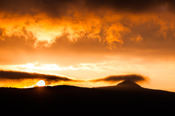 Obraz premium Jested Mountain hidden in the clouds. Dramatic red sky at sunset time. Liberec, Czech Republic.