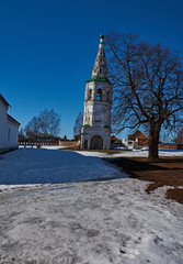 "Falling" bell tower/City landscape of Suzdal. The white stone bell tower is strongly tilted to the side. The fall effect is obtained.Suzdal.Golden Ring of Russia