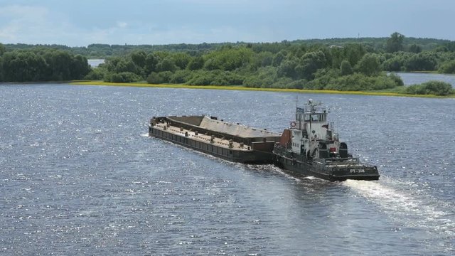 Top view of seascape - empty barge without cargo float along the river in summer sunny day