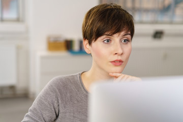 frau schaut nachdenklich auf ihren computer
